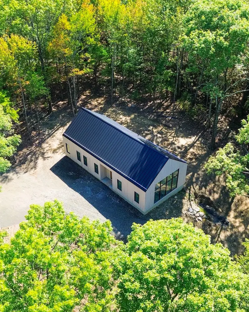 Overhead drone shot of modern metal-roof home in the woods, drone photography Hudson Valley