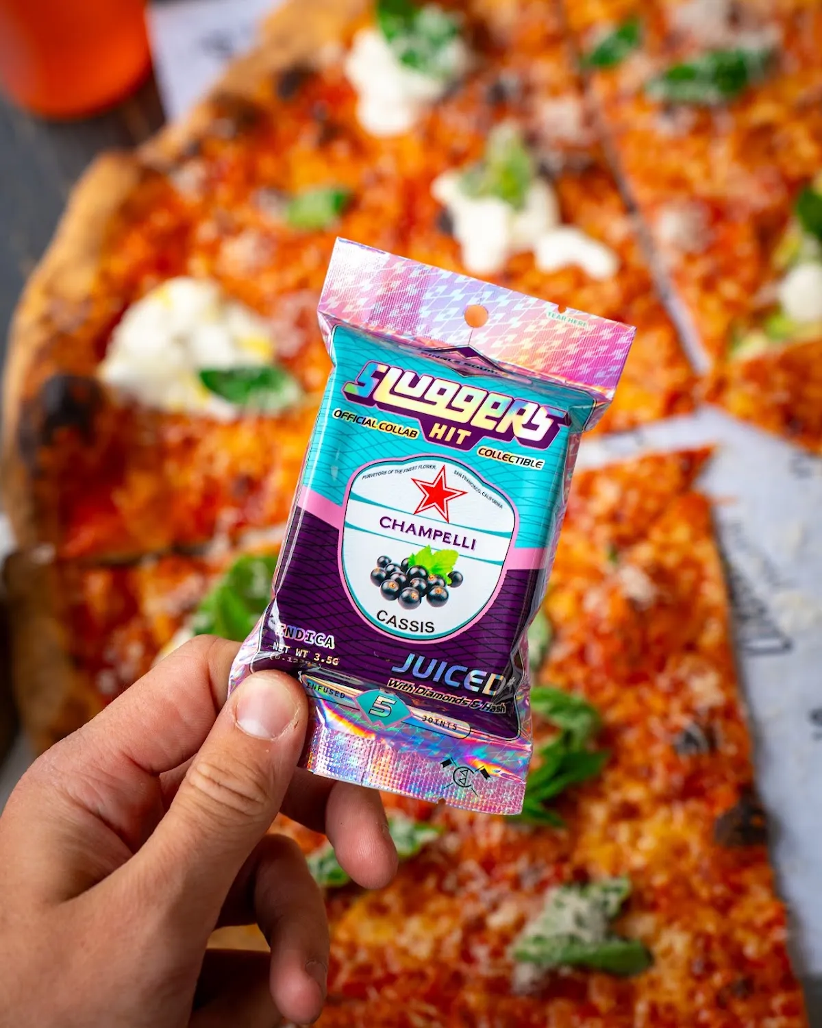 Cannabis pack held over wood-fired pizza, cannabis lifestyle photography