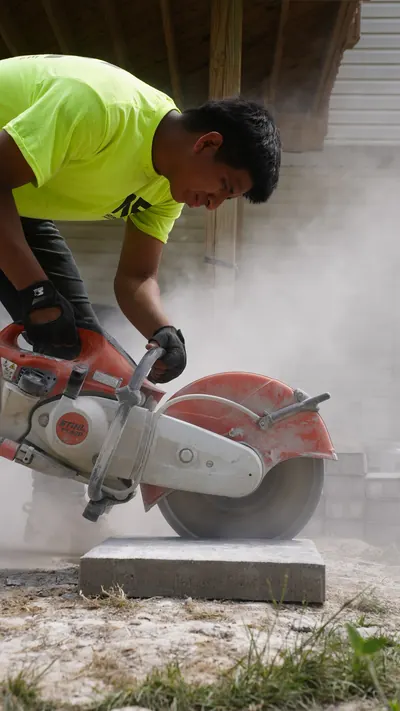 Natures Edge crew cutting stone, construction photography by Evolved Media